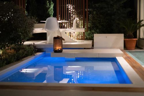 a swimming pool at night with a candle in the water at City Loft Hotel in Patra