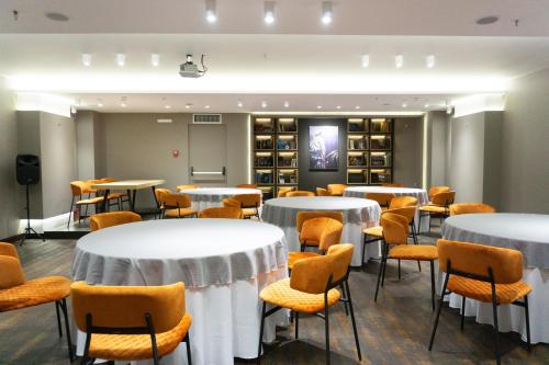 a room with white tables and chairs and wine bottles at City Loft Hotel in Patra