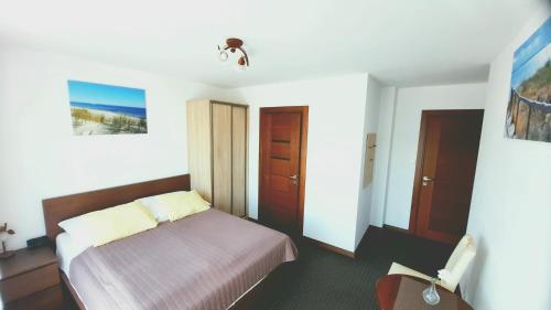 a bedroom with a bed and a chair in it at Morska Fala in Jastarnia