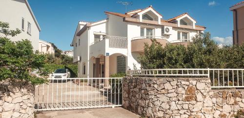 una grande casa bianca con una recinzione in pietra di Beach Apartment w Sea Views, 3x Bedrooms w En-Suites a Šibenik