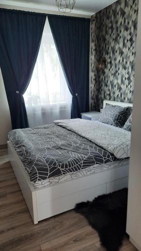 1 dormitorio con 1 cama grande y ventana en Апартаменти поруч із Софіївським парком Dolce Vita, en Uman