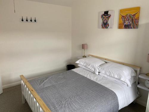 um quarto com uma cama e duas fotografias na parede em 1st Floor Flat in Mews em Kessingland