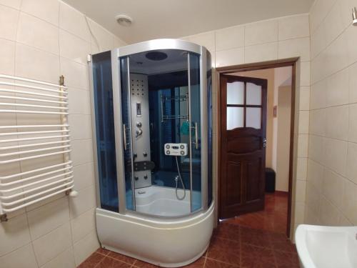 a bathroom with a shower with a glass door at Apartament Helenka in Supraśl