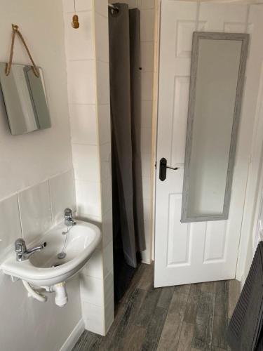 uma casa de banho com um lavatório branco e um espelho. em 1st Floor Flat in Mews em Kessingland