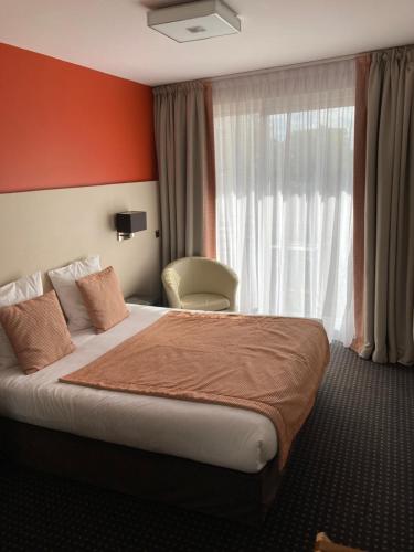 a hotel room with a bed and a window at Hotel Georges in Pléneuf-Val-André