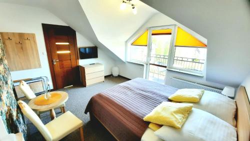 a bedroom with a bed and a chair and a window at Morska Fala in Jastarnia