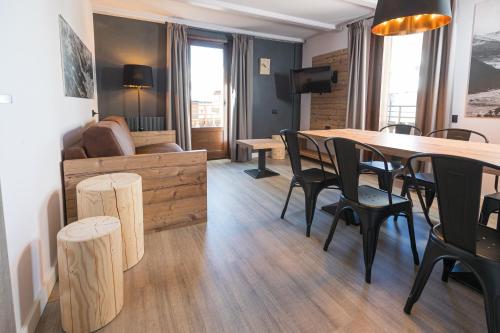 - un salon avec une table, des chaises et un canapé dans l'établissement Appartamenti Roby - Appartamenti Abar, à Livigno
