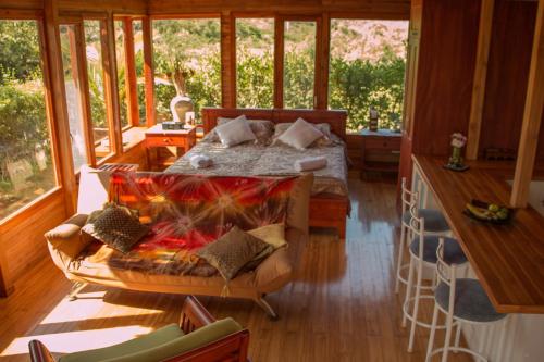 a bedroom with a bed in a room with windows at Chez Manany Galapagos Ecolodge in Puerto Villamil