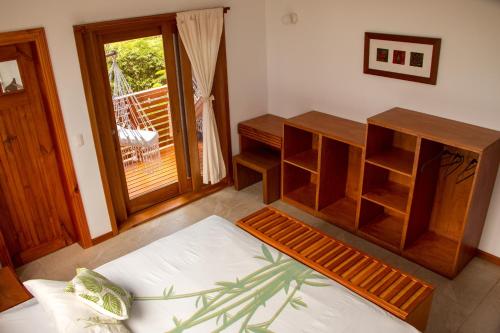 a living room with a bed and a balcony at Chez Manany Galapagos Ecolodge in Puerto Villamil