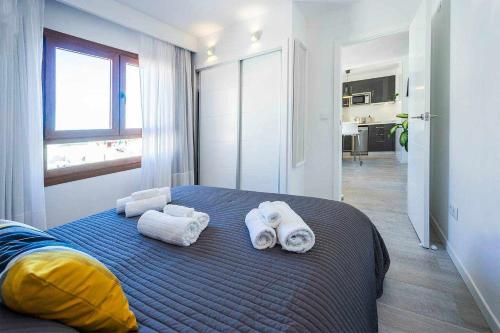 een slaapkamer met een bed met handdoeken erop bij Apartamento Rambla 36 in Alicante