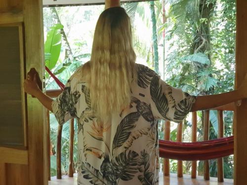 a woman in a dress looking out of a window at Cariblue Beach and Jungle Resort in Puerto Viejo