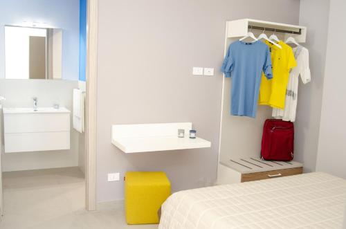 una camera con letto, lavandino e specchio di Solemare Casa Vacanze a Castellammare del Golfo