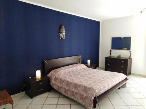 Appartamento Asia في ليباري: غرفة نوم بسرير وجدار ازرق