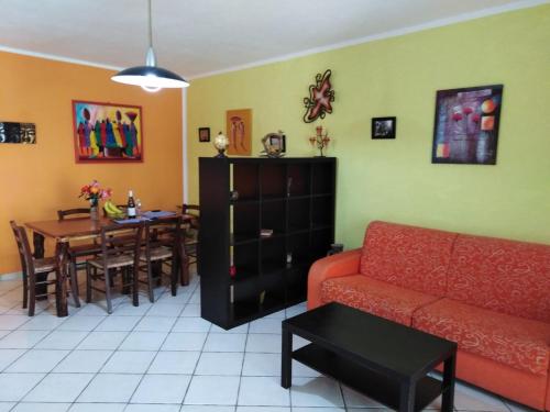 een woonkamer met een rode bank en een tafel bij Appartamento Asia in Lipari