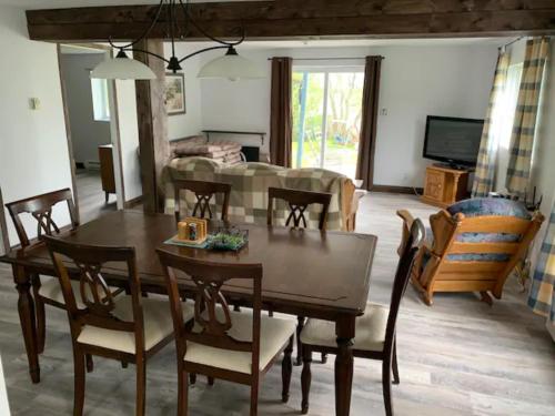 a dining room and living room with a table and chairs at La Grange sur le Lac App A et B in Saint Romain