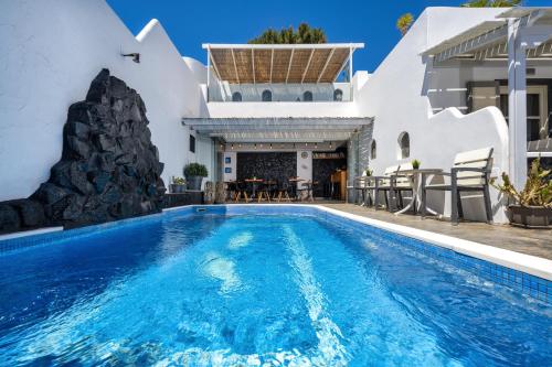 a villa with a swimming pool and a house at Plastiras Rooms in Fira