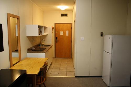 a kitchen with a wooden table and a refrigerator at CHINOOK INN in Rocky Mountain House