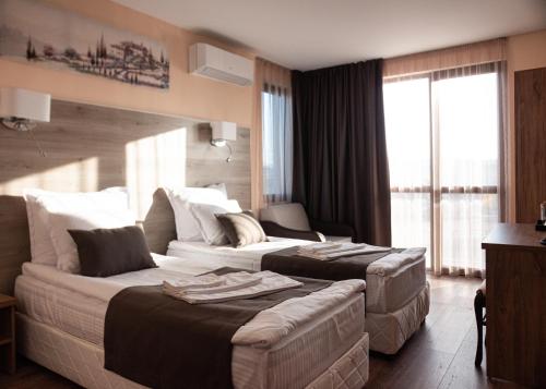 a hotel room with two beds and a couch at Hotel Vanilla, Varna - Free parking in Varna City