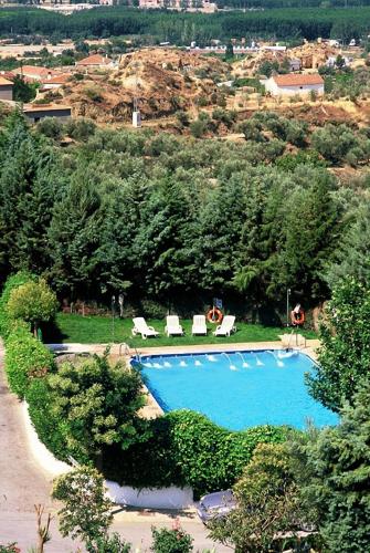 a large swimming pool with lounge chairs and trees at Cuevas Pedro Antonio de Alarcon in Guadix