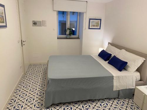 een slaapkamer met een groot bed met blauwe kussens bij William Apartment Sorrento in Sorrento
