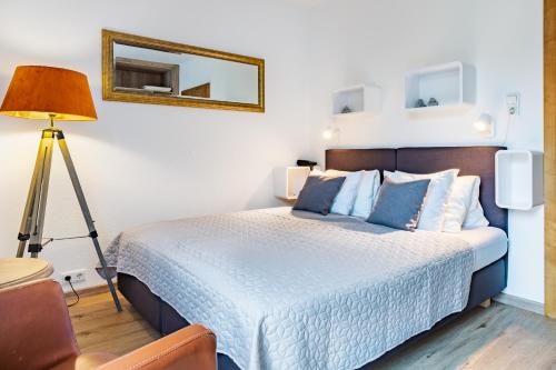 a bedroom with a bed with blue pillows and a mirror at Hotel Seehof in Zell am See