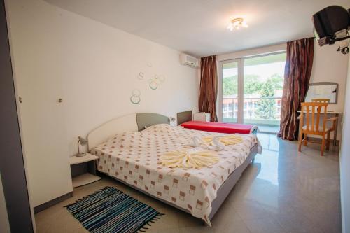 a bedroom with a large bed and a balcony at MNG Holiday Yassen Apartments in Sunny Beach