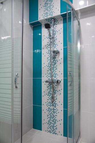 a bathroom with a shower with blue and white tiles at Hotel Vanilla, Varna - Free parking in Varna City