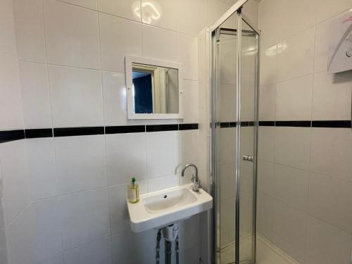 uma casa de banho com um lavatório e uma cabina de duche em vidro. em City Chic - King's Cross Apartments em Londres