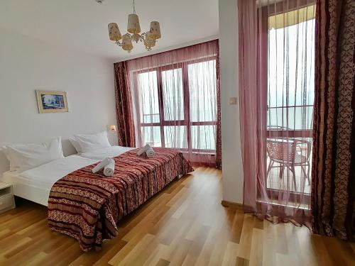 sypialnia z łóżkiem i dużym oknem w obiekcie Cabacum Plaza Beach Apartments - High-Speed WiFi w Złotych Piaskach