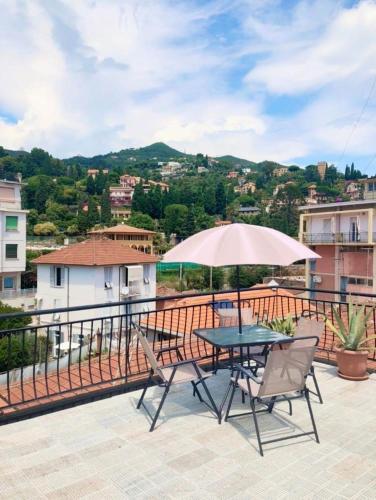 una mesa y sillas con una sombrilla en el balcón en Hotel Alla Fontanella, en Alassio