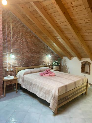 a bedroom with a large bed in a brick wall at Il Giglio Affittacamere in Tortolì
