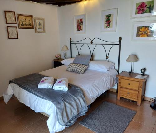 a bedroom with a bed with two slippers on it at VV Casa Bastina "by henrypole home" in Mazo