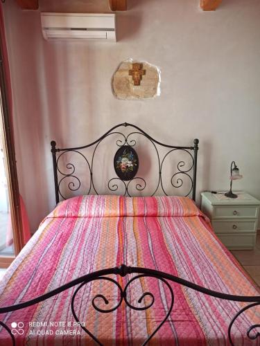 a bedroom with a bed with a colorful comforter at Bed & Breakfast Onda Blu in Porto SantʼElpidio