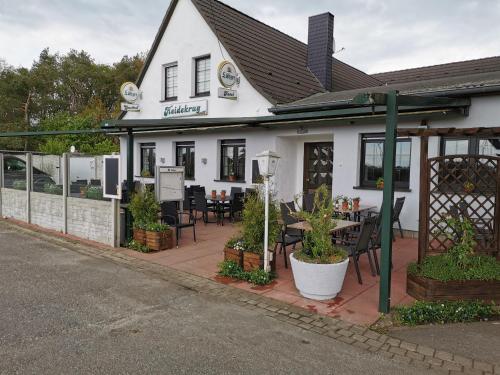 ein Restaurant mit Tischen und Stühlen vor einem Gebäude in der Unterkunft Gasthof & Hotel Heidekrug in Plau am See