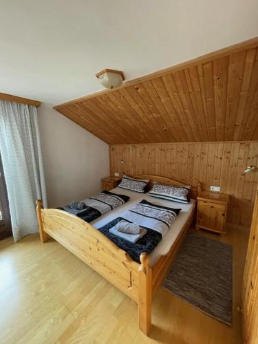 ヴェステンドルフにあるHaus Mariandlの木製の天井の客室のベッド1台分です。