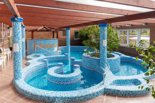 a pool in a resort with blue mosaics at Bagolyvár Inárcs in Inárcs