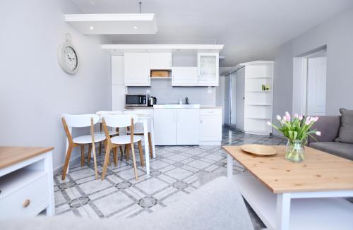 uma cozinha e sala de estar com mesa e cadeiras em Wolski Apartments - Reymonta 15 em Kolobrzeg