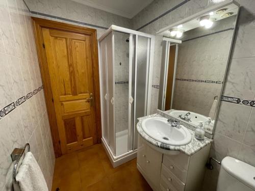 a bathroom with a sink and a shower and a mirror at Apartamentos rurales La Casa Vieja De Alceda in Alceda