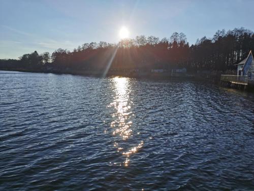 a view of a lake with the sun reflecting on the water at Gasthof & Hotel Heidekrug in Plau am See