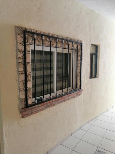 a window on the side of a room with a tile floor at Hotel Chely in Bernal