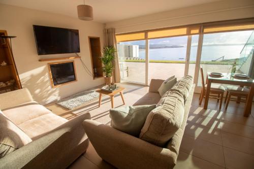 a living room with a couch and a fireplace and a table at At The Beach Rooms in Portstewart