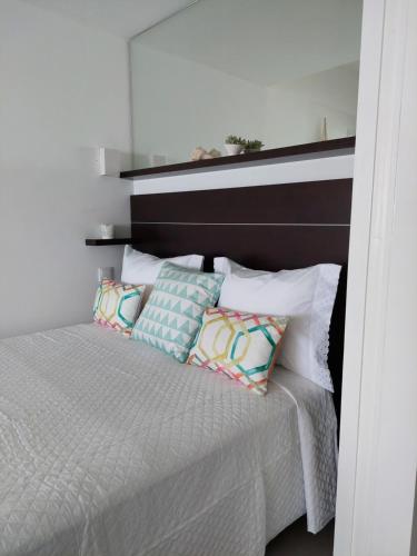 um quarto com uma cama com uma cabeceira e almofadas pretas em Acqua Marine em Sesimbra