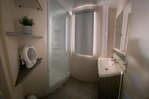 a small bathroom with a sink and a shower at Mobil home climatisé 6 personnes dans camping 3* Tohapi a BOOFZHEIM in Boofzheim