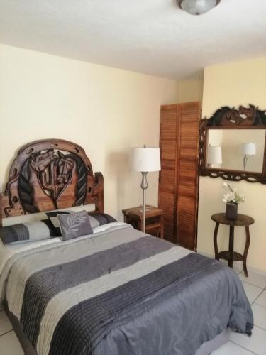 a bedroom with a large bed with a wooden headboard at Hotel Chely in Bernal