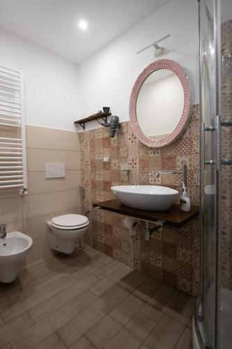 a bathroom with a sink and a toilet and a mirror at un posto al sole in Molino Nuovo