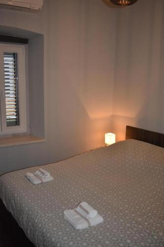 a bedroom with a bed with two towels on it at Apartmani Trklja in Trebinje