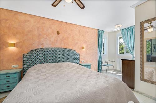 um quarto com uma cama grande e um espelho em Townhouse at Los Naranjos GC em Marbella
