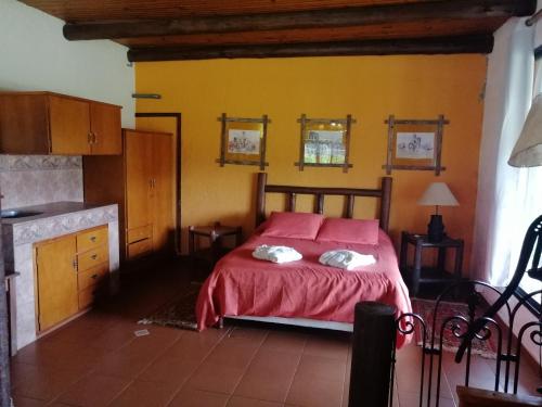 a bedroom with a bed with a red bedspread at Estancia Renacimiento in Atlántida