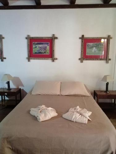 two towels sitting on a bed in a bedroom at Estancia Renacimiento in Atlántida