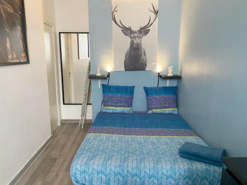 - une chambre avec un lit avec une tête de cerf sur le mur dans l'établissement 010 CHIC & COSY F1 29m2 HYPERCENTRE WIFI SMART TV NETFLIX, à Saint-Étienne